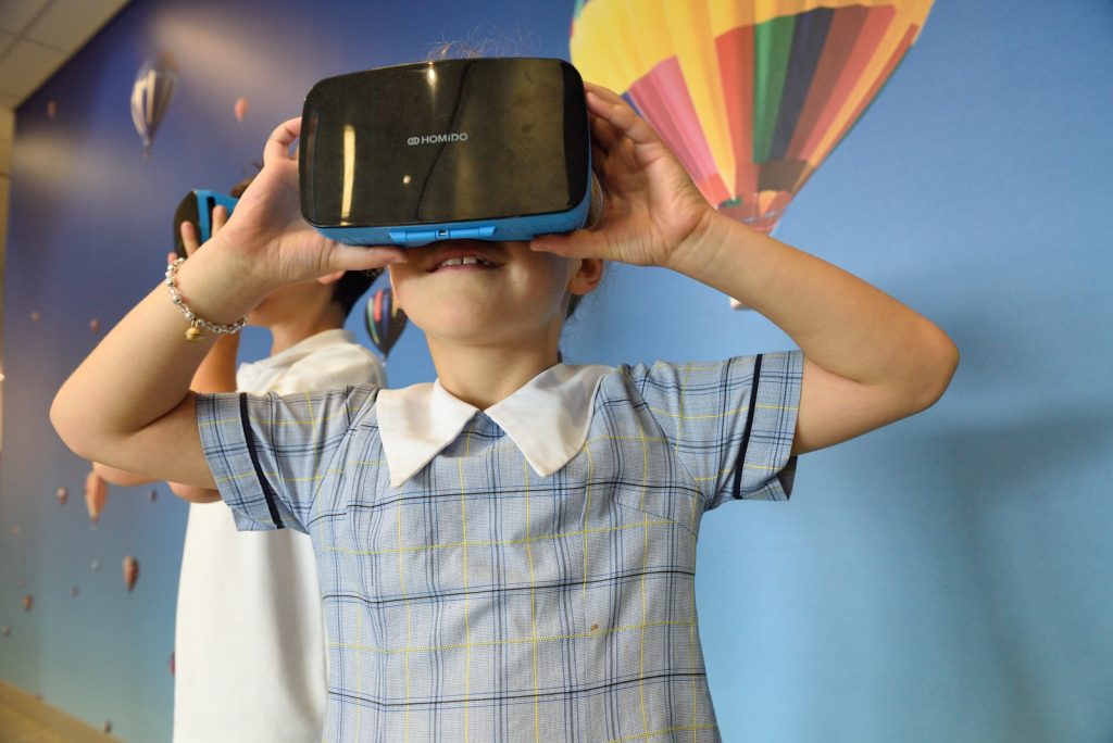 boys using blue and black virtual reality headset